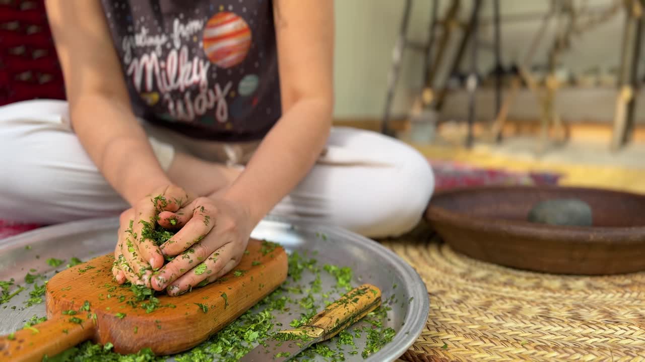 cortar verduras en la tabla de cortar una mujer trabajar en casa vida tradicional procesamiento de alimentos hechos a mano en el bosque campo rural cocina persa comida vegana deliciosa cocina receta de comida aplastar sentarse mimbre