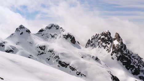 drone flight over cima d'asta summit of dolomite mountain range covered with snow