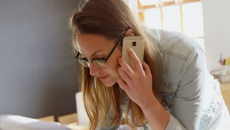 Weibliche-Schmuckdesignerin,-Die-Mit-Dem-Mobiltelefon-Spricht,-Während-Sie-Einen-Laptop-4K-Benutzt