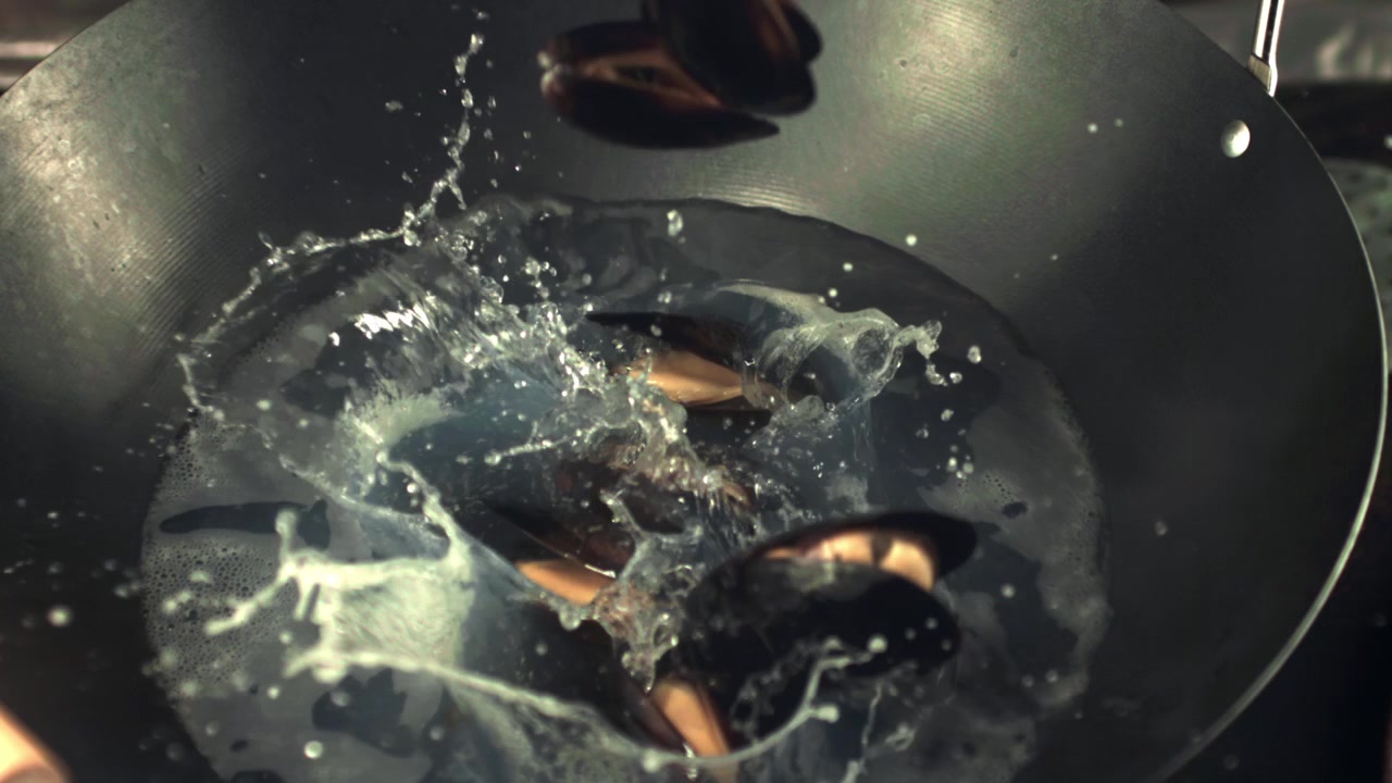 Slow Motion Mussels Dropping into Boiling Water in Wok