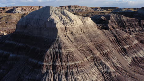 drone rotating around a rock formation on a dusty badland