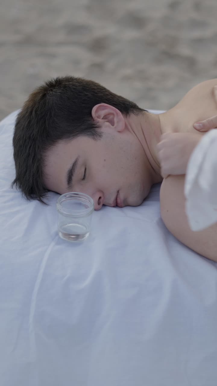 A man receiving an outdoor back massage, possibly with cupping therapy