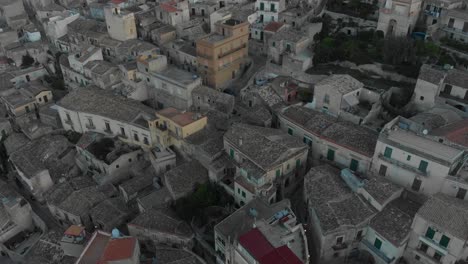 Vista-De-Arriba-Hacia-Abajo-Del-Casco-Antiguo-De-Modica-En-Sicilia-Durante-El-Amanecer,-Aérea