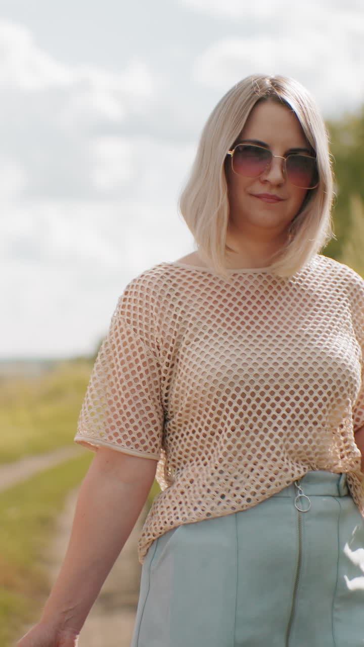 madre e hija con gafas de sol caminando por un camino de exuberante vegetación, madre con paraguas, con vista parcial del niño pequeño a su lado, disfrutando de un tranquilo paseo al aire libre bajo la brillante luz del sol
