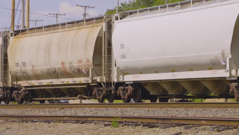 a train pulling white hopper cars rolling along the railroad tracks in the rust belt of youngstown, ohio