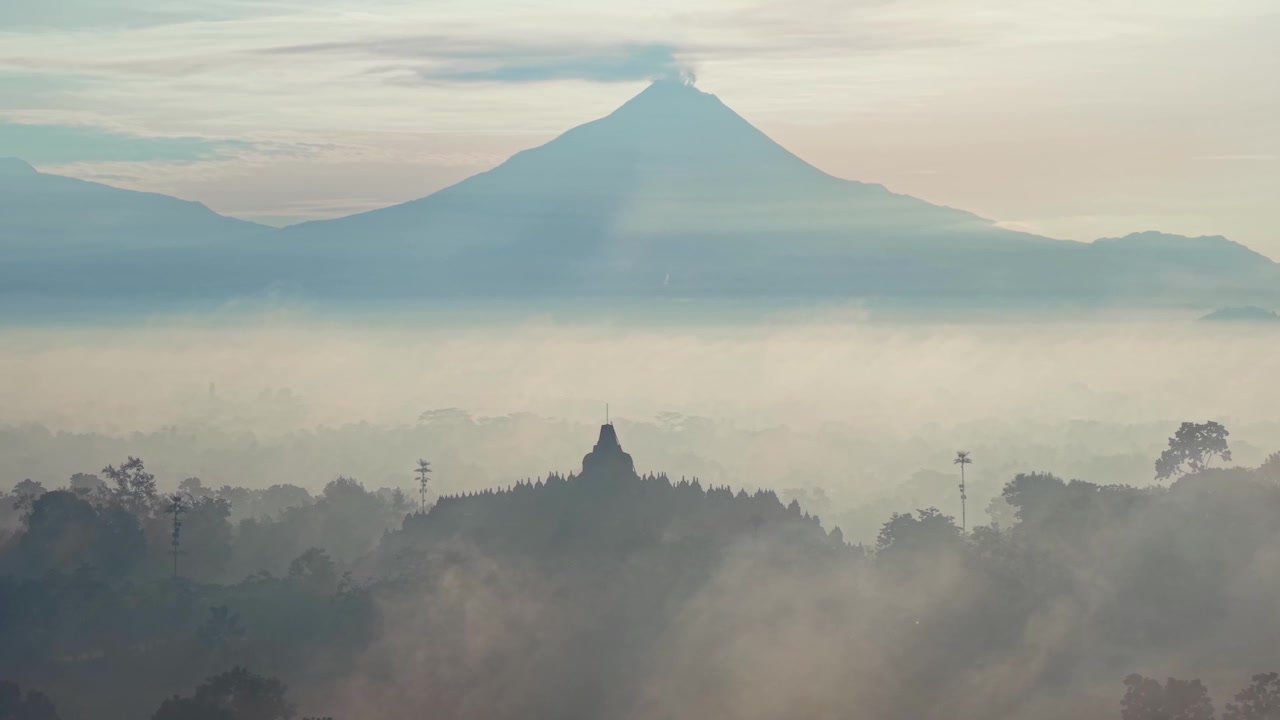 Scena mattutina nebbiosa del Tempio di Borobudur con sfondo montuoso, che evoca un'atmosfera serena e un paesaggio mozzafiato per temi di viaggio e spiritualità
