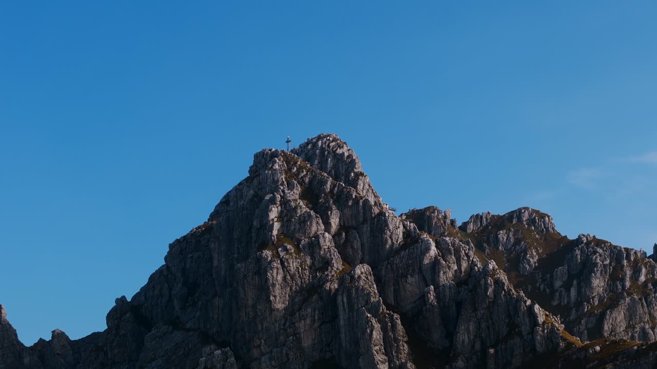 Veduta aerea ascendente della croce di vetta del Monte Resegone e del Rifugio Azzoni