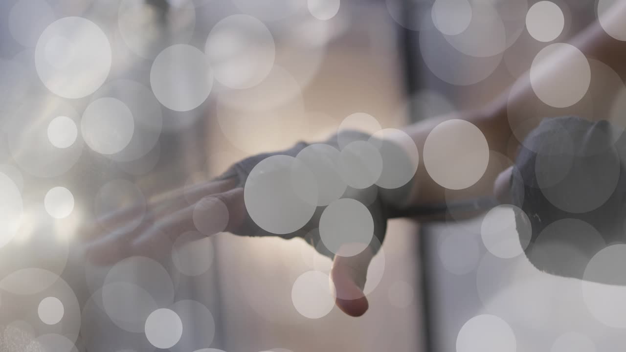Mid-adult female reaching forward, securing grips on handles, preparing workout while bokeh moving
