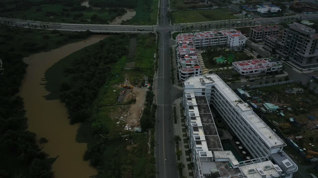 vuele sobre nuevos desarrollos, humedales y carreteras que revelan vistas del río y del horizonte de la ciudad con torres de gran altura temprano en la mañana.