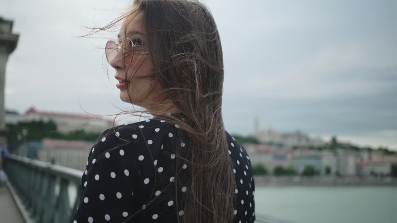 mujer caminando por un puente en una ciudad