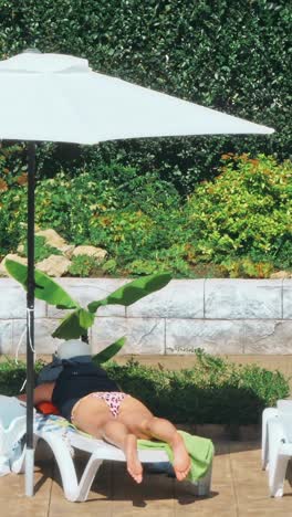 una joven sensual relajándose cerca de la piscina.
