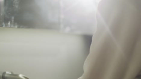 아침에 화장실에서 목욕 가운을 입고 손을 씻는 갈색 머리 여자