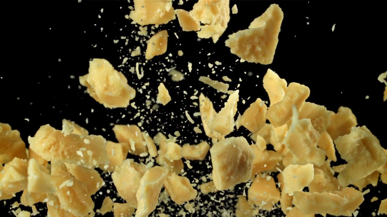 Scaglie di Parmigiano che cadono e si disperdono al rallentatore