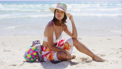 Una-Mujer-Joven-Y-Bonita-Sentada-En-La-Arena-De-La-Playa