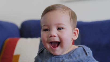 baby smiling and laughing playing with a blue silk with yellow stars in slow motion