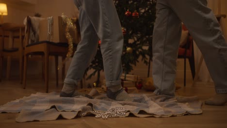 familia bailando alrededor del árbol de navidad