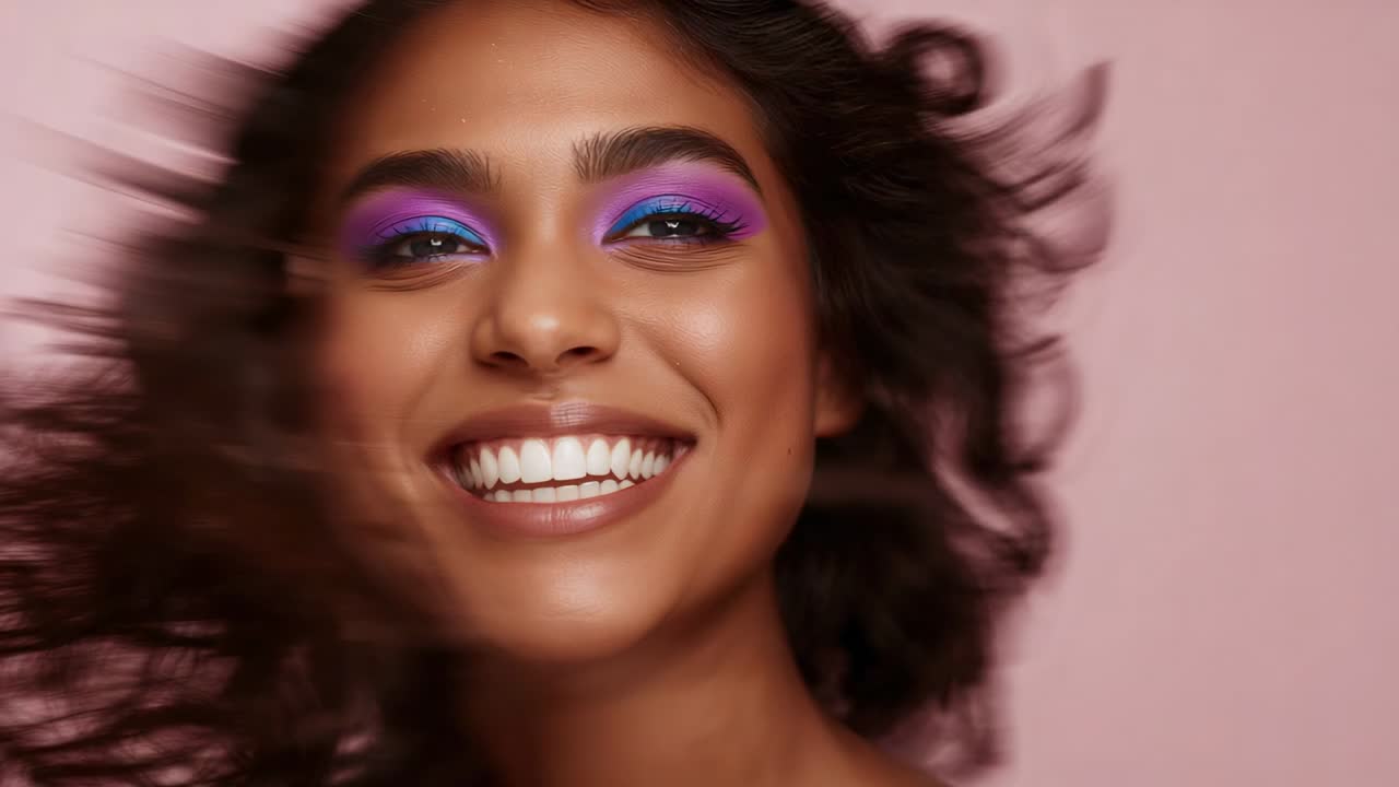 Smiling female model turning head in studio, camera rolling, showcasing purple blue eyeshadow