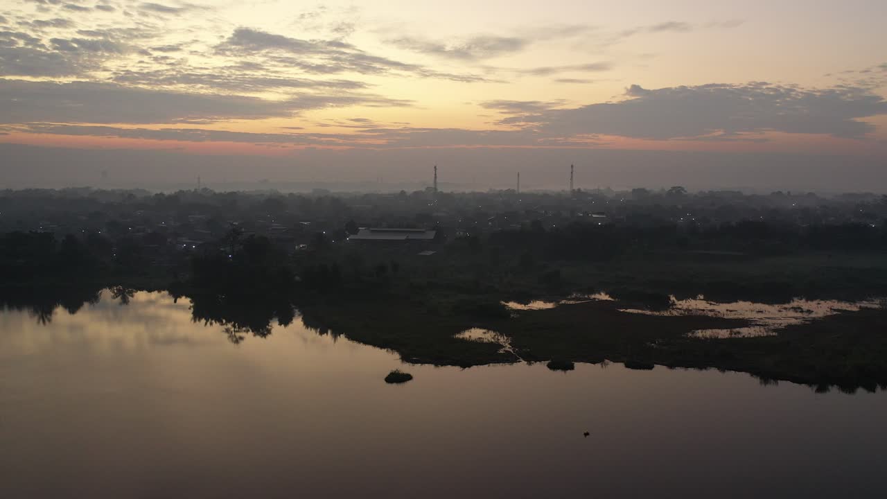 amanecer sobre un lago y una ciudad