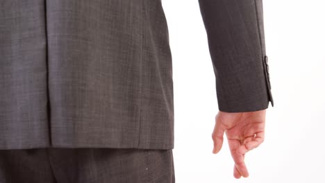 man standing with finger crossed against white background