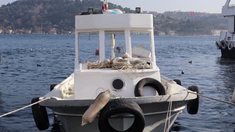 small fishing boat floating in bosporus tied in pier of istanbul, turkey