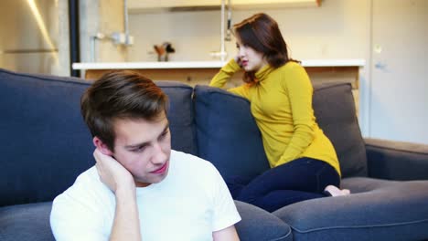 mujer ignorando al hombre mientras discuten en la sala de estar