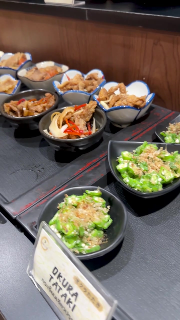 Kameraet panorerer hen over forskellige japanske sideretter i små keramikskåle på en restaurant i Bangkok.