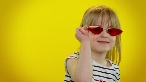 Playful-happy-child-girl-in-sunglasses-blinking-eye,-looking-at-camera-with-smile,-winking,-flirting