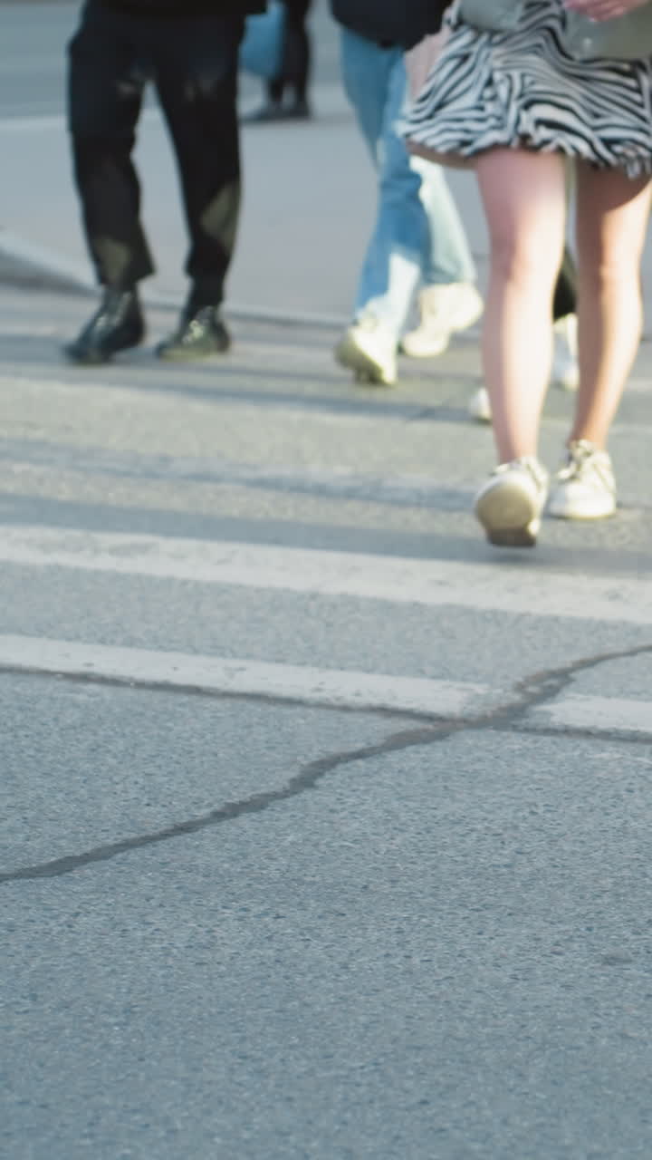 A city view showcasing a black car parked on the side of the road with people walking across the street