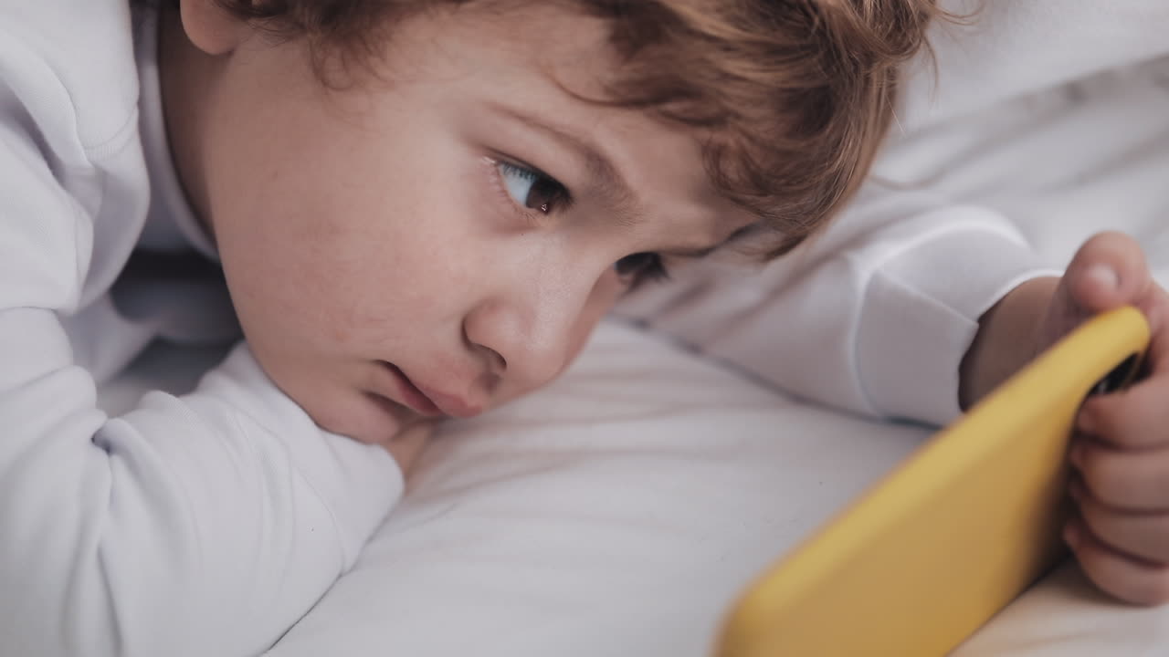 Boy Watching Smartphone in Bed