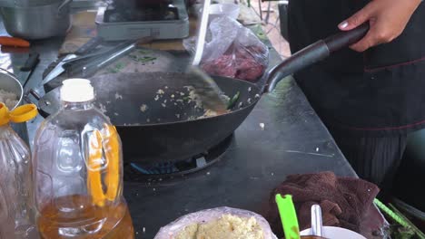 slow motion shot of street food vendor stir frying a rice dish