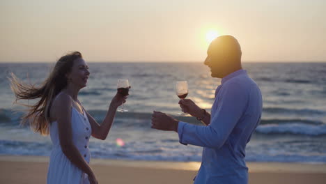 Couple-drinking-wine-and-dancing-on-beach