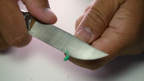 Footage-of-hands-slowly-sharpening-a-pencil-and-some-coloured-pencils-with-a-sharp-knife