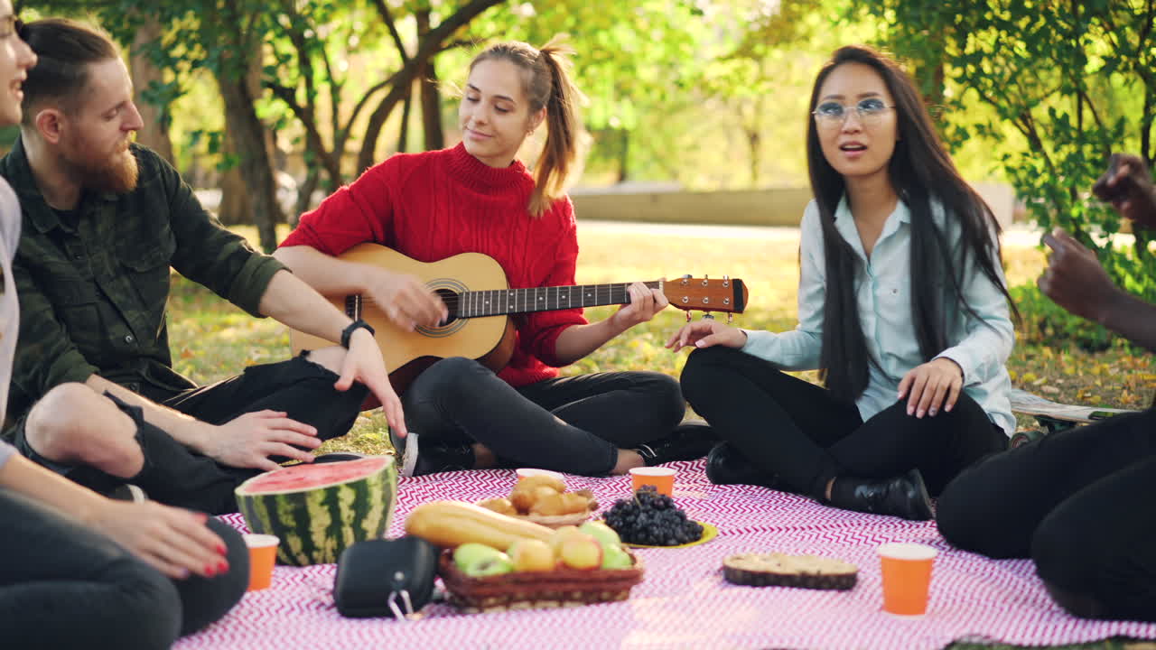 Friends Enjoying a Picnic in the Park with Music