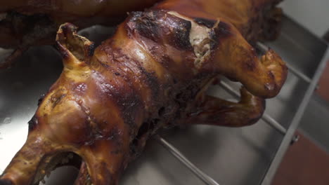 young piglet roasted, cooling on kitchen stand - overhead close up slow-motion