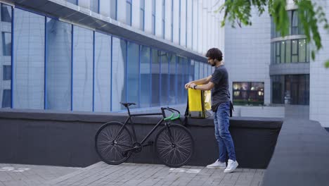 Courier-zipping-his-delivery-backpack-and-ready-to-go