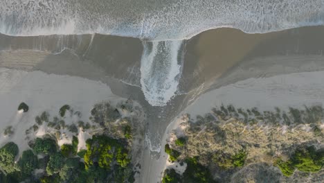 aerial top down drone shot of high tide rivers at pismo beach california at sunrise