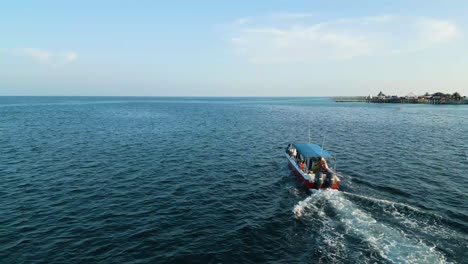 Aerial-view-behind-touristic-boat-on-water-on-Celebes-Sea-at-sunset-in-Malaysia