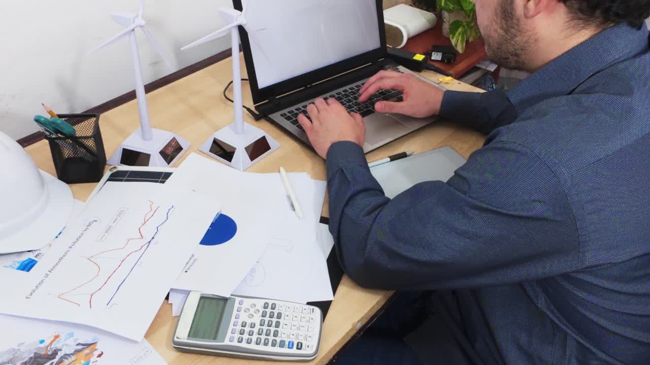 Analyst Performing Data Entry on a Laptop for a Green Project