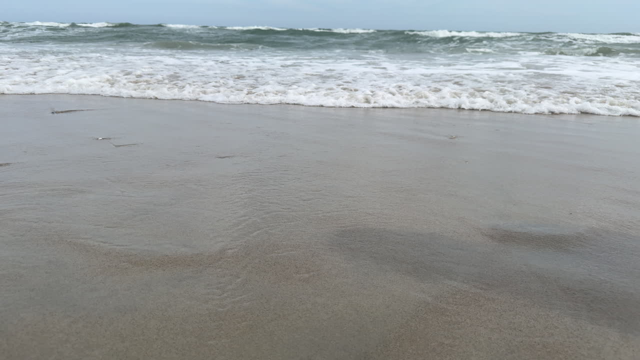Young person walking through the surf