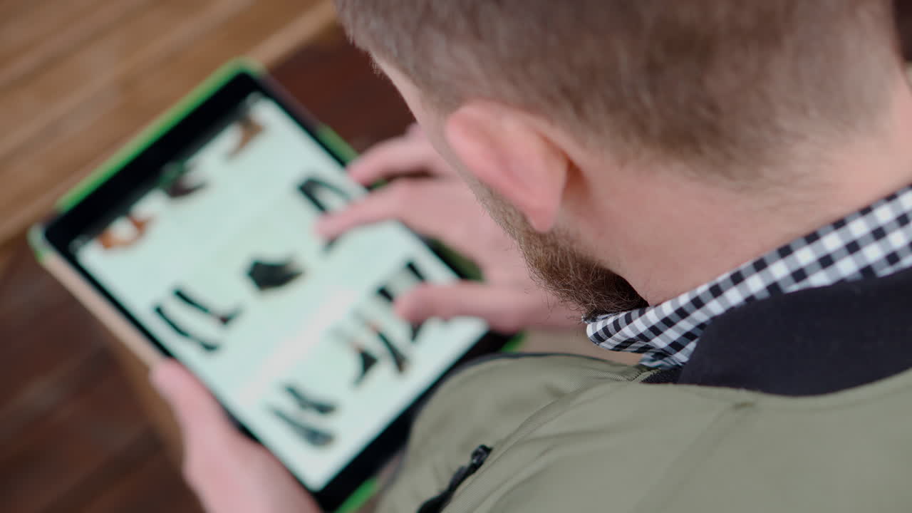 hombre navegando zapatos en línea en una tableta