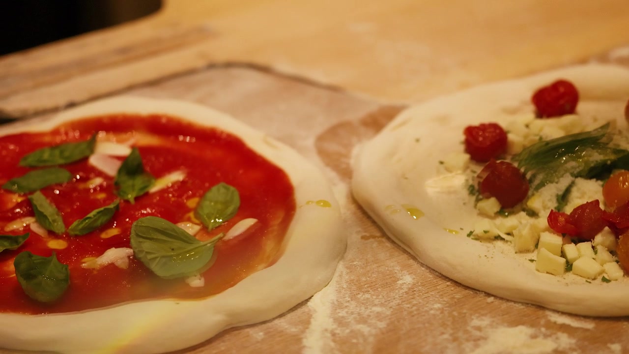 Impasto fresco per pizza in preparazione con condimenti in una cucina