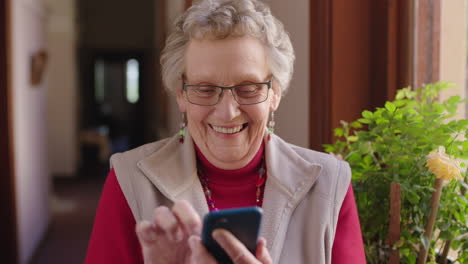 Porträt-Einer-Glücklichen-älteren-Kaukasischen-Frau-Im-Altersheim,-Die-Mit-Der-Smartphone-Messaging-App-SMS-Schreibt-Und-Surft