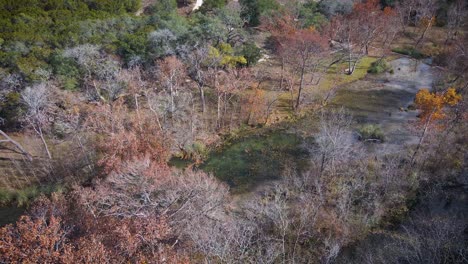 Ein-Clearwater-Creek-Liegt-In-Wimberley,-Isoliert-Mitten-Im-Texanischen-Hügelland,-Während-Die-Verstreuten-Bäume-Und-Blätter-Beginnen,-In-Warme-Farben-Zu-Wechseln