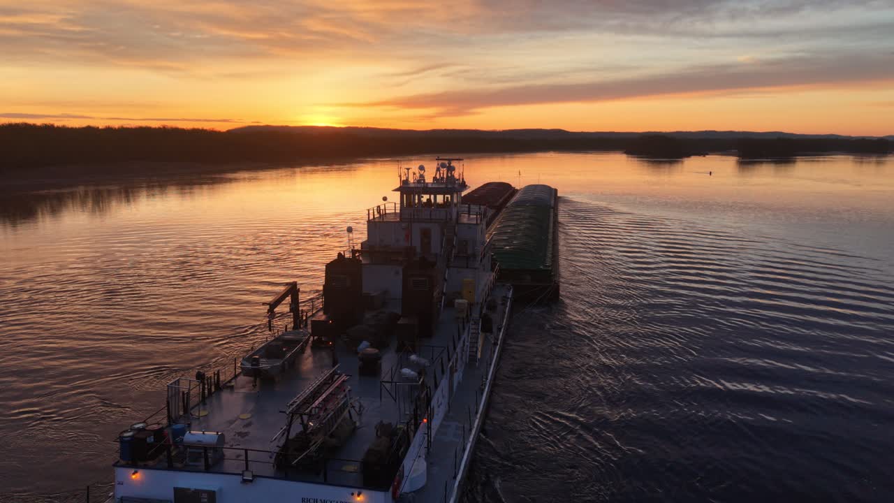 Aerial View of Tugboat Pushing Barges on River at Sunset