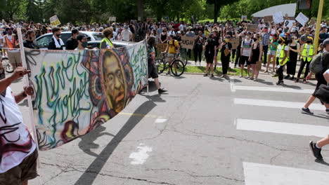 peaceful black lives matter protesters march in minneapolis with banner