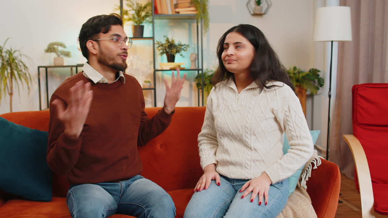 Upset disappointed young couple girlfriend boyfriend arguing fighting quarrel shouting at each other