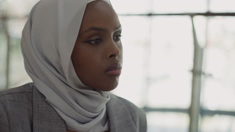 upset african-american woman with hijab in office hall