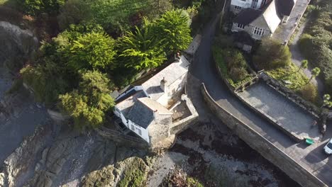 aerial drone tilt shot of an english mill house on the shoreline of a coastal village - lee bay, beach, ilfracombe, devon, england