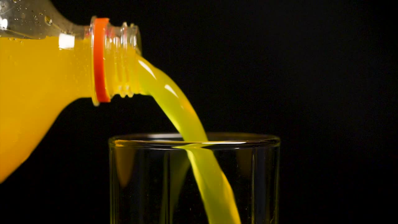 Versamento di aranciata in un bicchiere