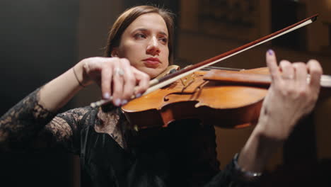 woman is playing violin on scene of philharmonic hall portrait of talented woman musician